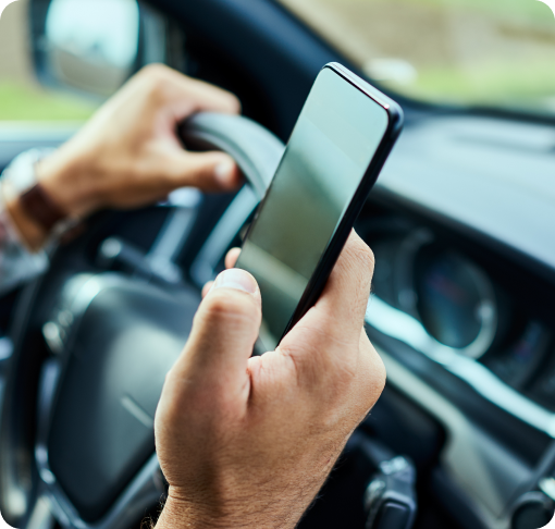 Image of a person using his phone while driving