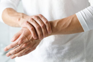 man holding his hands suffering from crps